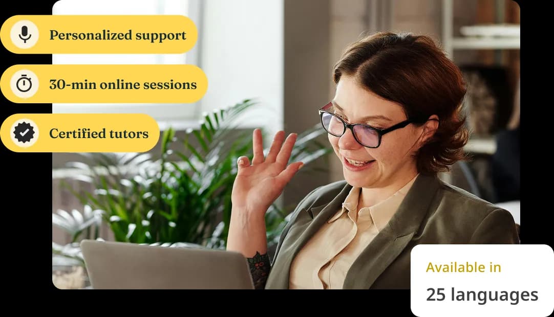 A woman waves and smiles at her laptop during an online tutoring session